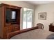 Main bedroom with television cabinet, sliding door access to the patio, and decorative painting at 1488 Squaw Ln, North Port, FL 34286