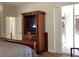 Main bedroom with television cabinet, sliding door access to the patio, and neutral walls at 1488 Squaw Ln, North Port, FL 34286