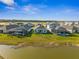 Back view of neighborhood homes featuring screened patios and lush lawns, set against a picturesque lake at 16029 Mulrion Blvd, Punta Gorda, FL 33982