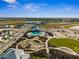 Aerial view of neighborhood amenities, including pool, trails, and recreation area with a scenic backdrop at 16029 Mulrion Blvd, Punta Gorda, FL 33982