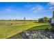Lush backyard featuring manicured lawn, landscaping, and screened-in porch with water views at 16029 Mulrion Blvd, Punta Gorda, FL 33982