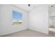 Bright bedroom with ceiling fan, window with blinds, and neutral tile flooring at 16029 Mulrion Blvd, Punta Gorda, FL 33982