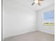 Bright bedroom with ceiling fan, window with blinds, and neutral tile flooring at 16029 Mulrion Blvd, Punta Gorda, FL 33982