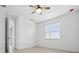 Bright bedroom with ceiling fan, window with blinds, and neutral tile flooring at 16029 Mulrion Blvd, Punta Gorda, FL 33982