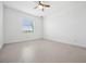 Bright bedroom with ceiling fan, window with blinds, and neutral tile flooring at 16029 Mulrion Blvd, Punta Gorda, FL 33982