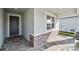 Covered front porch with stone accents, tiled flooring, and stylish front door at 16029 Mulrion Blvd, Punta Gorda, FL 33982