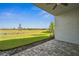 Covered patio with stylish pavers overlooking a lush green lawn and serene water view at 16029 Mulrion Blvd, Punta Gorda, FL 33982