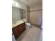 This bathroom features earth-toned tiles, wooden vanity and a shower with glass doors at 19583 Kapok Ct, Port Charlotte, FL 33952