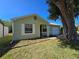 Charming single-story home with a green lawn and a beautiful shade tree at 19583 Kapok Ct, Port Charlotte, FL 33952