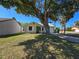 Cozy single-story home with green lawn, mature shade tree and attached garage at 19583 Kapok Ct, Port Charlotte, FL 33952