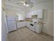 Bright kitchen featuring white cabinets, standard appliances, and tile flooring at 19583 Kapok Ct, Port Charlotte, FL 33952