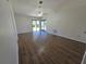 Spacious living room featuring wood floors, ceiling fan, and sliding doors to the backyard at 19583 Kapok Ct, Port Charlotte, FL 33952