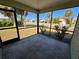 This screened porch offers views of a manicured lawn and palm trees at 19583 Kapok Ct, Port Charlotte, FL 33952