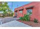 Side view of a coral home with tile roof accents, and a brick paver sidewalk with tropical landscaping at 2002 Central Ave, Sarasota, FL 34234