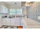 Bright kitchen featuring white cabinets, quartz countertops, and stylish patterned tile backsplash at 2002 Central Ave, Sarasota, FL 34234