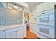 White kitchen with ample cabinet space, tile floor, and a view into an adjacent room at 2002 Central Ave, Sarasota, FL 34234