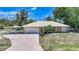 Inviting single Gathering home with a well manicured front yard, attached two car garage and covered parking area at 22435 Fortune Ave, Port Charlotte, FL 33954