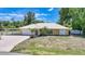 Charming home exterior with a well-manicured lawn, carport, and a two-car garage at 22435 Fortune Ave, Port Charlotte, FL 33954