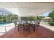 Outdoor dining area next to a sparkling swimming pool and screened enclosure at 22435 Fortune Ave, Port Charlotte, FL 33954
