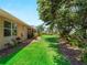 Lush backyard featuring mature trees, well-manicured lawn, and tropical landscaping at 2288 Prague Ln, Punta Gorda, FL 33983
