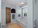 Bright bathroom featuring a large tub under a window, complemented by a tiled shower and neutral-toned tiles at 2288 Prague Ln, Punta Gorda, FL 33983