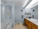 Bathroom featuring a soaking tub and dual sinks with wood cabinets at 2288 Prague Ln, Punta Gorda, FL 33983