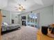 Primary bedroom with carpeted floors, ceiling fan, slider to pool and en suite bathroom at 2288 Prague Ln, Punta Gorda, FL 33983