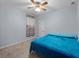 Cozy bedroom with a blue comforter on the bed, neutral carpet, ceiling fan and light blue walls at 2288 Prague Ln, Punta Gorda, FL 33983