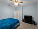 Bedroom features carpeted floors, ceiling fan, blue bedding, and a TV on a stand at 2288 Prague Ln, Punta Gorda, FL 33983