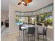 Bright breakfast nook with views of the pool and backyard, features a modern glass-top table at 2288 Prague Ln, Punta Gorda, FL 33983