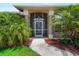 Inviting front entrance with decorative pillars and well-manicured landscaping featuring lush palms at 2288 Prague Ln, Punta Gorda, FL 33983