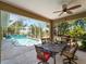 Covered patio with a dining table, overlooking a screened-in pool and lush backyard at 2288 Prague Ln, Punta Gorda, FL 33983
