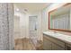 Bathroom featuring wood-look floors, vanity, shower, and linen closet at 23470 Burlingame Ave, Punta Gorda, FL 33980