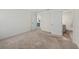 Bedroom showcasing doorways to bathroom and kitchen, with neutral carpet at 23470 Burlingame Ave, Punta Gorda, FL 33980