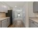 Open concept kitchen featuring stainless steel appliances and gray cabinets leading into adjacent living areas at 23470 Burlingame Ave, Punta Gorda, FL 33980
