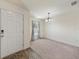 Inviting living room features plush carpet, a front door, and a decorative light fixture at 23470 Burlingame Ave, Punta Gorda, FL 33980