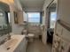 Well-lit bathroom with tile floor, ample storage, and view to the pool at 2500 Aquilos Ct, Port Charlotte, FL 33952