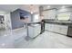 Modern kitchen features white cabinets, granite countertops, stainless steel appliances, and marble tile flooring at 2500 Aquilos Ct, Port Charlotte, FL 33952