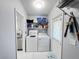 Well-equipped laundry room with washer, dryer, and ample shelving for storage at 2500 Aquilos Ct, Port Charlotte, FL 33952