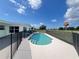 Backyard pool with fencing and view of the adjacent golf course under a partly cloudy sky at 2500 Aquilos Ct, Port Charlotte, FL 33952