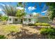 Backyard with a well-maintained lawn, mature trees, and a cozy outdoor patio area with a decorative fence at 31037 Prairie Creek Dr, Punta Gorda, FL 33982