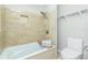 Bathroom with tiled shower and tub combination, with shelving and adjacent commode at 31037 Prairie Creek Dr, Punta Gorda, FL 33982