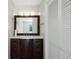 Bathroom vanity with dark wood cabinets, marble countertop, and a decorative framed mirror at 31037 Prairie Creek Dr, Punta Gorda, FL 33982