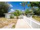 Exterior view of the home showcasing its well-maintained lawn, palm trees, and charming curb appeal at 31037 Prairie Creek Dr, Punta Gorda, FL 33982