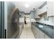Modern kitchen featuring stainless steel refrigerator, gray cabinets, and a tiled backsplash at 31037 Prairie Creek Dr, Punta Gorda, FL 33982