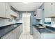 Bright kitchen with stainless steel appliances, gray cabinetry, and an open view to another room at 31037 Prairie Creek Dr, Punta Gorda, FL 33982