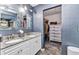 Double sink bathroom vanity with granite counters opens to walk-in closet with shelving and chest of drawers at 3104 Garbett Ter, North Port, FL 34288