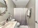 Well-lit bathroom features a large mirror, neutral colors, and a shower with a decorative curtain at 3104 Garbett Ter, North Port, FL 34288