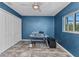 Blue office space features a ceiling fan, neutral floors, large window, and a closet for storage at 3104 Garbett Ter, North Port, FL 34288