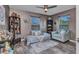Cozy bedroom featuring a sitting area, accent wall, ceiling fan, and shelving for collectibles at 3104 Garbett Ter, North Port, FL 34288